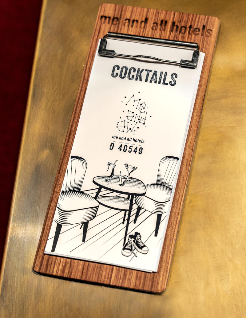 Foto: Cocktailkarte mit Zeichnung eines Cocktailtisches, Cocktailsesseln und einem Paar 'Chucks' Schuhe